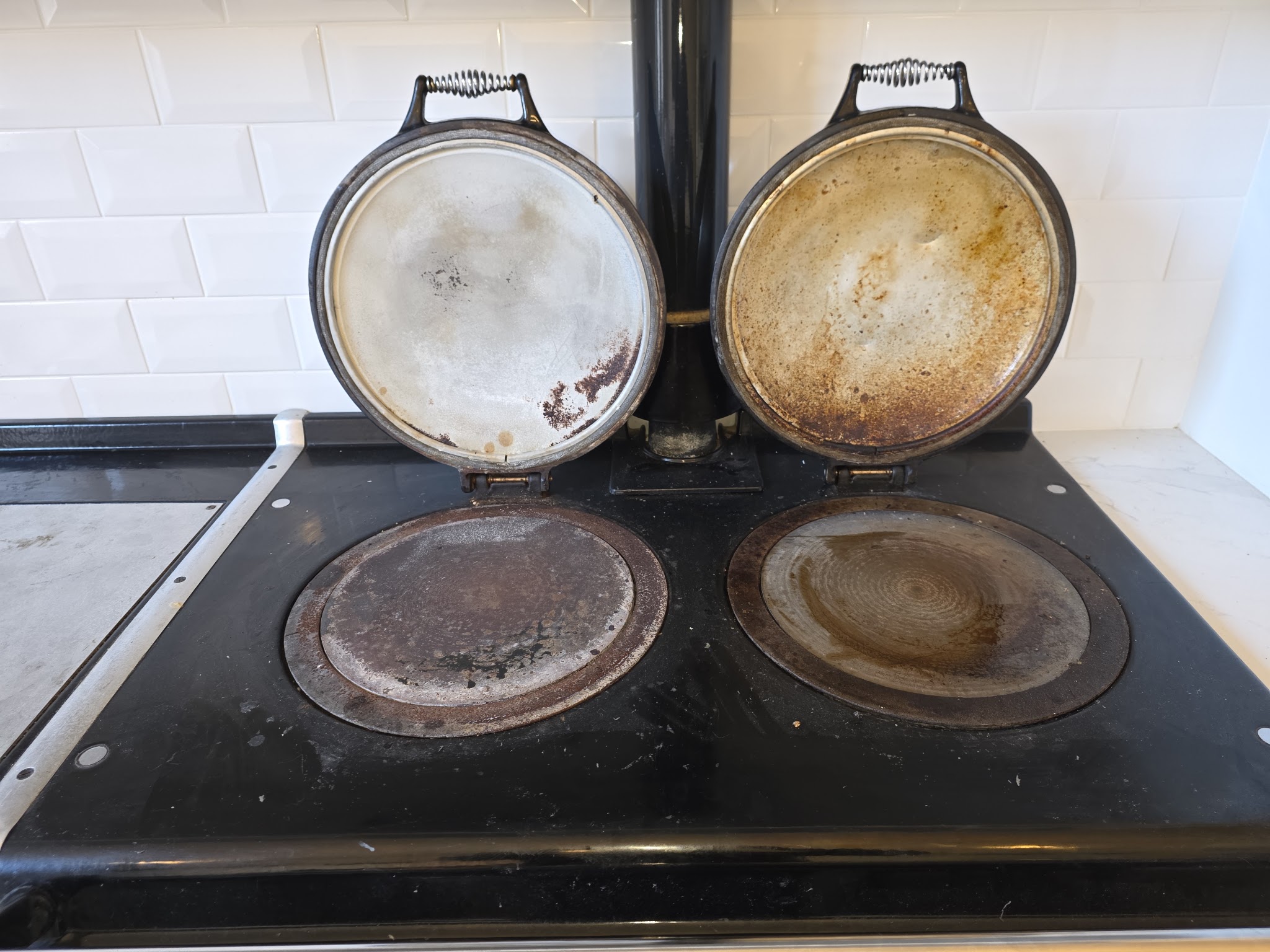 Aga hotplates and lids with burnt-on grime before cleaning